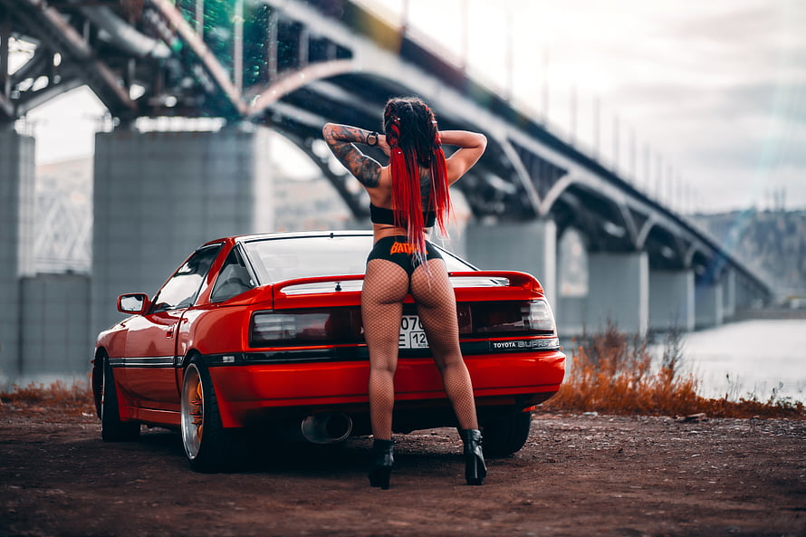 Red Toyota Supra with Woman in Fishnets Under Steel Bridge HD wallpaper