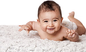 Smiling Indian Baby Lying On White Textured Blanket HD wallpaper