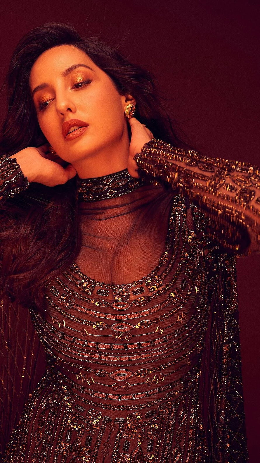Nora Fatehi in an ornate sequined gown with warm cinematic lighting HD phone wallpaper