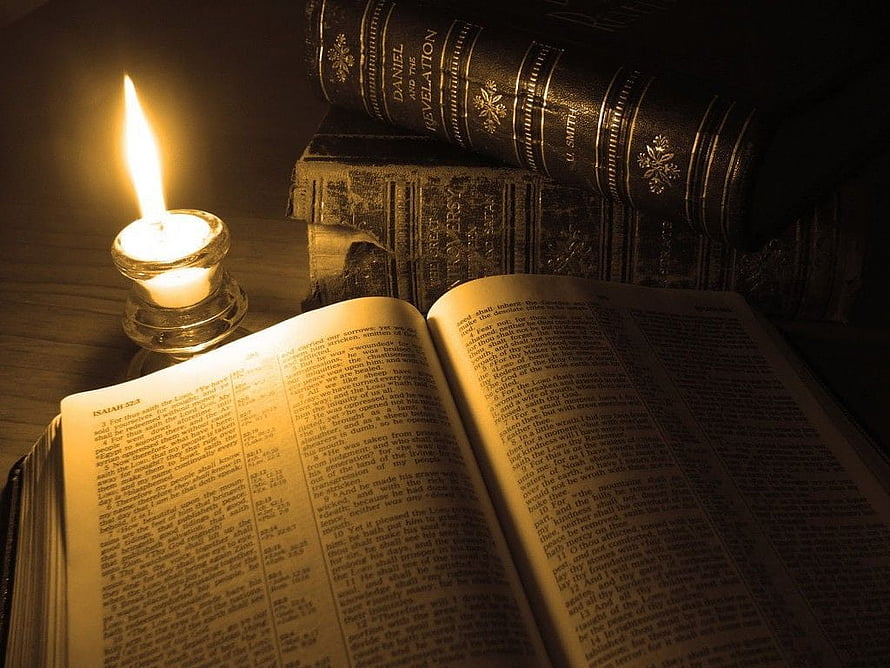 Open Bible and Candlelight with Stacked Leather Books in Warm Dim Lighting HD wallpaper