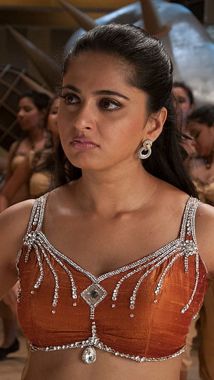 Anushka Shetty in ornate orange blouse with silver embellishments and traditional jewelry HD phone wallpaper