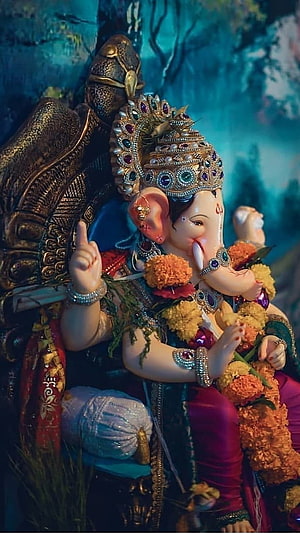 Ornate Ganesha Idol Adorned With Jewels And Marigold Garland In Temple Setting HD phone wallpaper