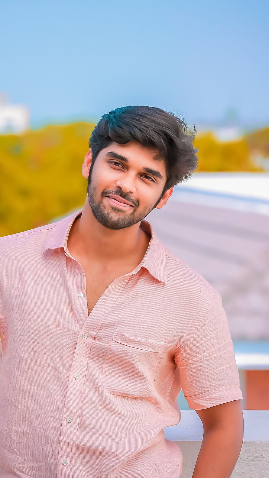 Dhruv Vikram in a light pink shirt with a soft outdoor background HD phone wallpaper