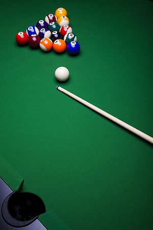 Pool table with racked balls, cue stick, and cue ball on green felt HD phone wallpaper