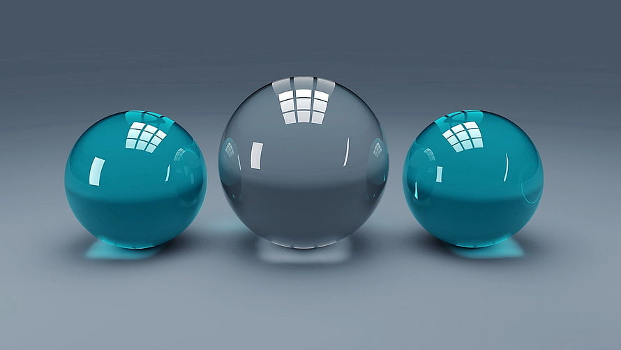 Three glossy glass spheres in teal and clear tones on a neutral gray studio background HD wallpaper