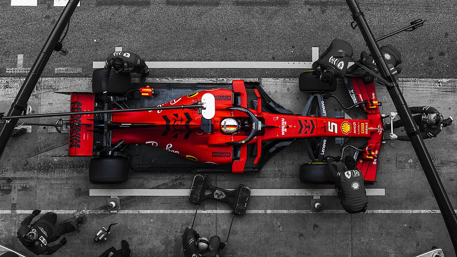 Top-Down View of a Red Ferrari Formula 1 Car During a Pit Stop HD wallpaper
