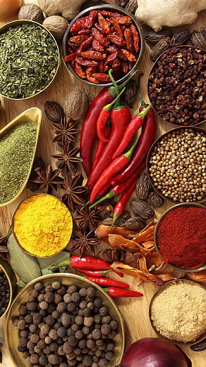 Vibrant Assortment of Whole and Ground Spices Arranged on a Wooden Surface HD phone wallpaper