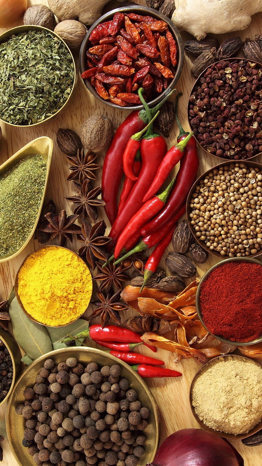 Vibrant Assortment of Whole and Ground Spices Arranged on a Wooden Surface HD phone wallpaper