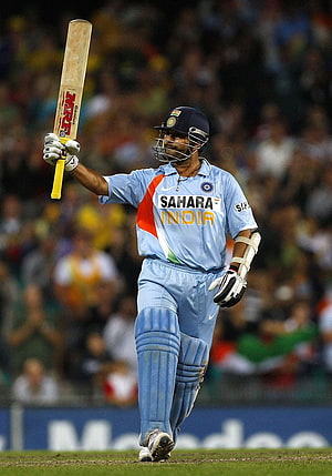 Sachin Tendulkar raising his bat in celebration during an India cricket match HD phone wallpaper