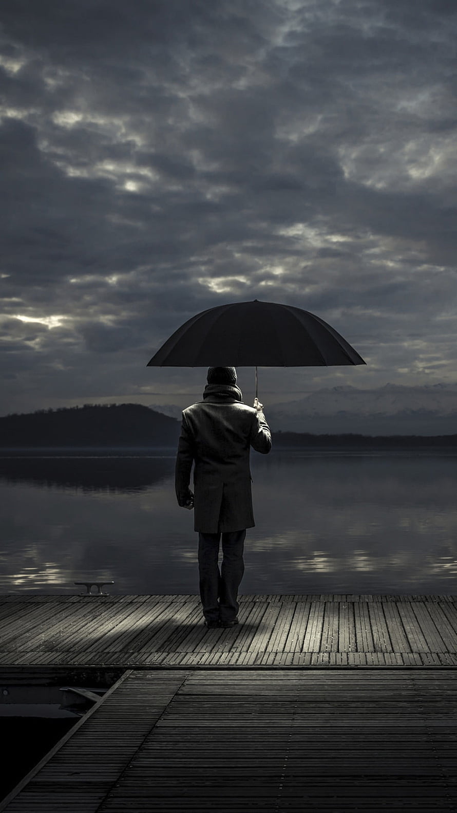 Solitary Man Standing on Wooden Dock with Umbrella Under Stormy Sky HD phone wallpaper