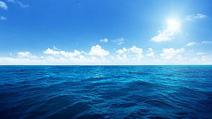 Serene Open Ocean Horizon Under Bright Blue Sky With Scattered Clouds HD wallpaper