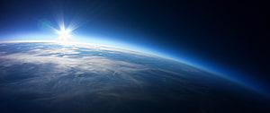 Earth Sunrise From Orbit With Bright Sun Flare And Atmospheric Glow HD wallpaper