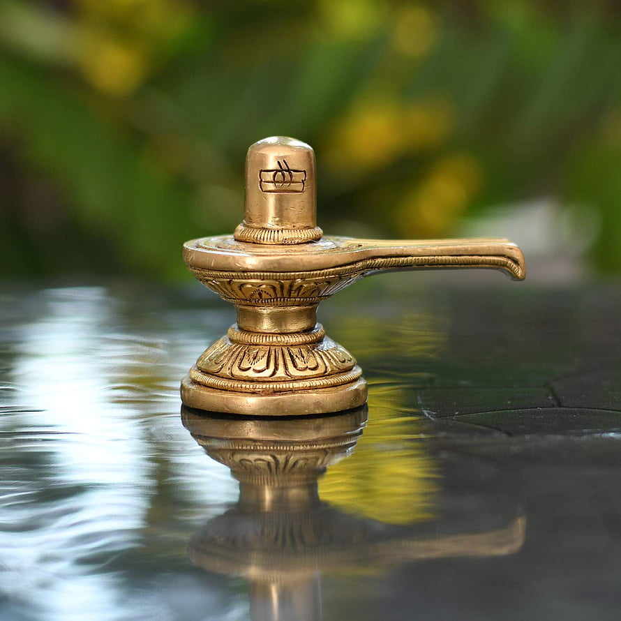Ornate Brass Shivlinga with Om Symbol on Reflective Surface HD phone wallpaper