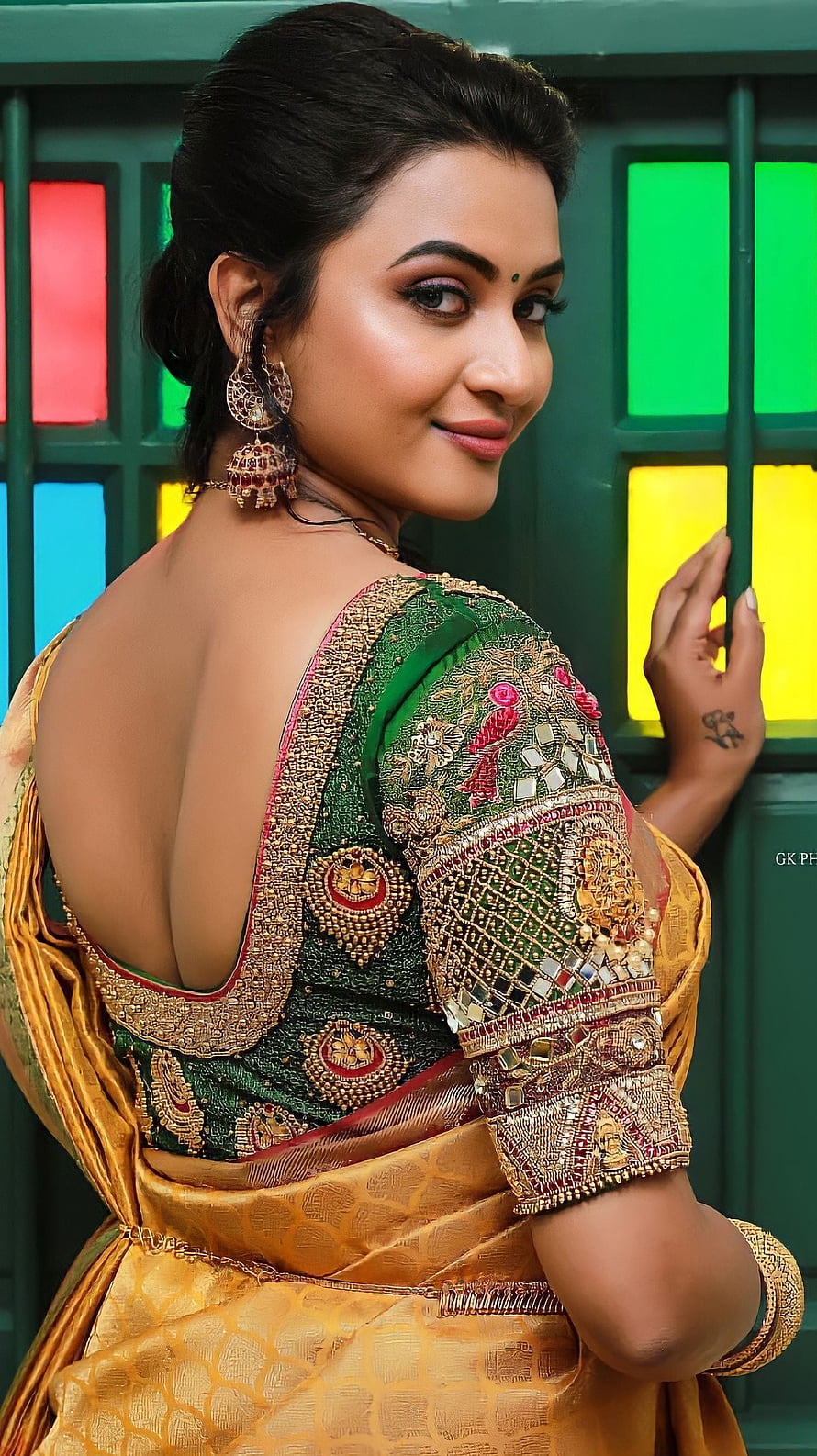 Janani Ashok Kumar in an ornate green and gold embroidered saree with traditional jewelry HD phone wallpaper