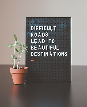 Inspirational Lightbox Quote with Small Potted Plant on Minimalist Desk HD phone wallpaper
