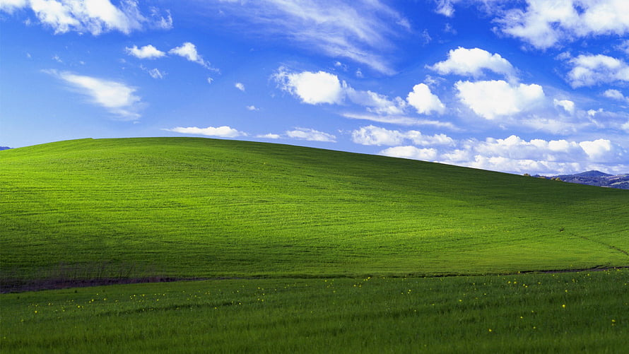 Rolling Green Hills Under a Bright Blue Sky with Scattered Clouds HD wallpaper