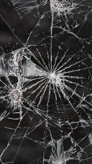 Shattered Glass Texture with Radiating Cracks on Dark Background HD phone wallpaper