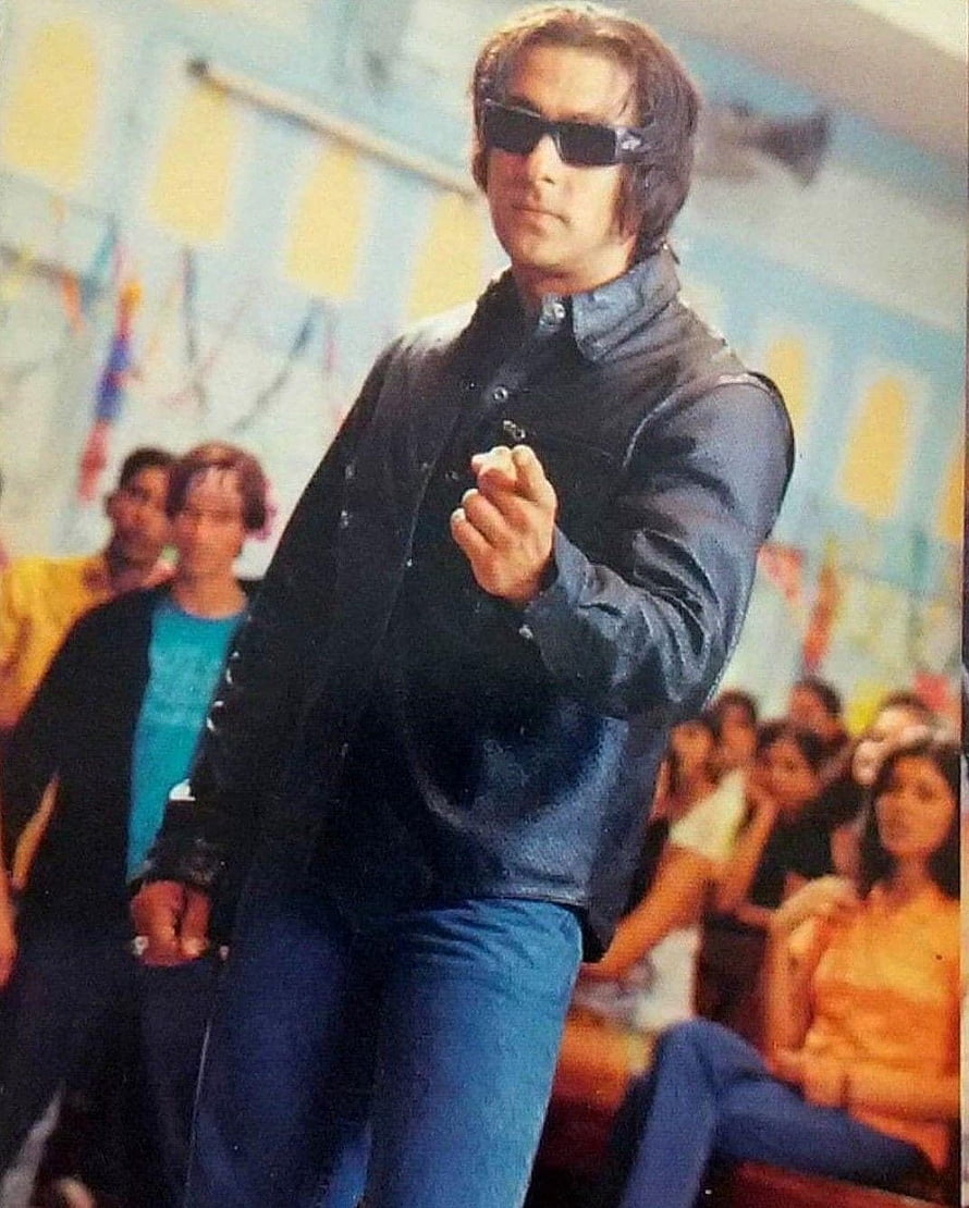 Salman Khan in a dark jacket and sunglasses pointing forward in a crowded indoor scene HD phone wallpaper
