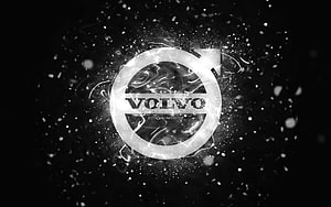 Volvo emblem with glowing white neon ring and particle effects on a dark abstract background HD wallpaper
