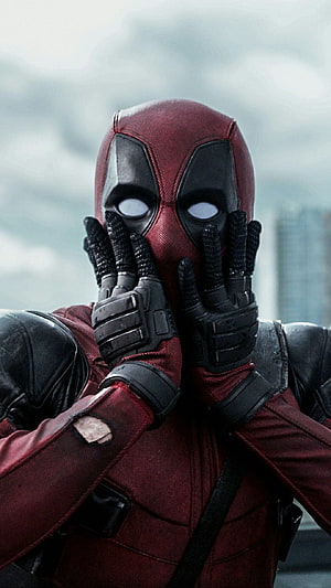 Deadpool Covering Face With Gloves in Red and Black Suit Against Overcast Sky HD phone wallpaper