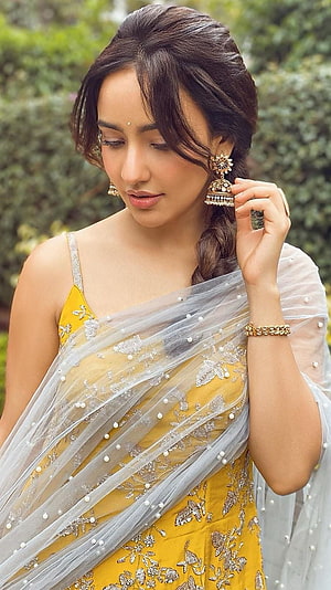 Neha Sharma in a yellow embroidered sari with sheer pearl-dotted dupatta and traditional gold jewelry HD phone wallpaper