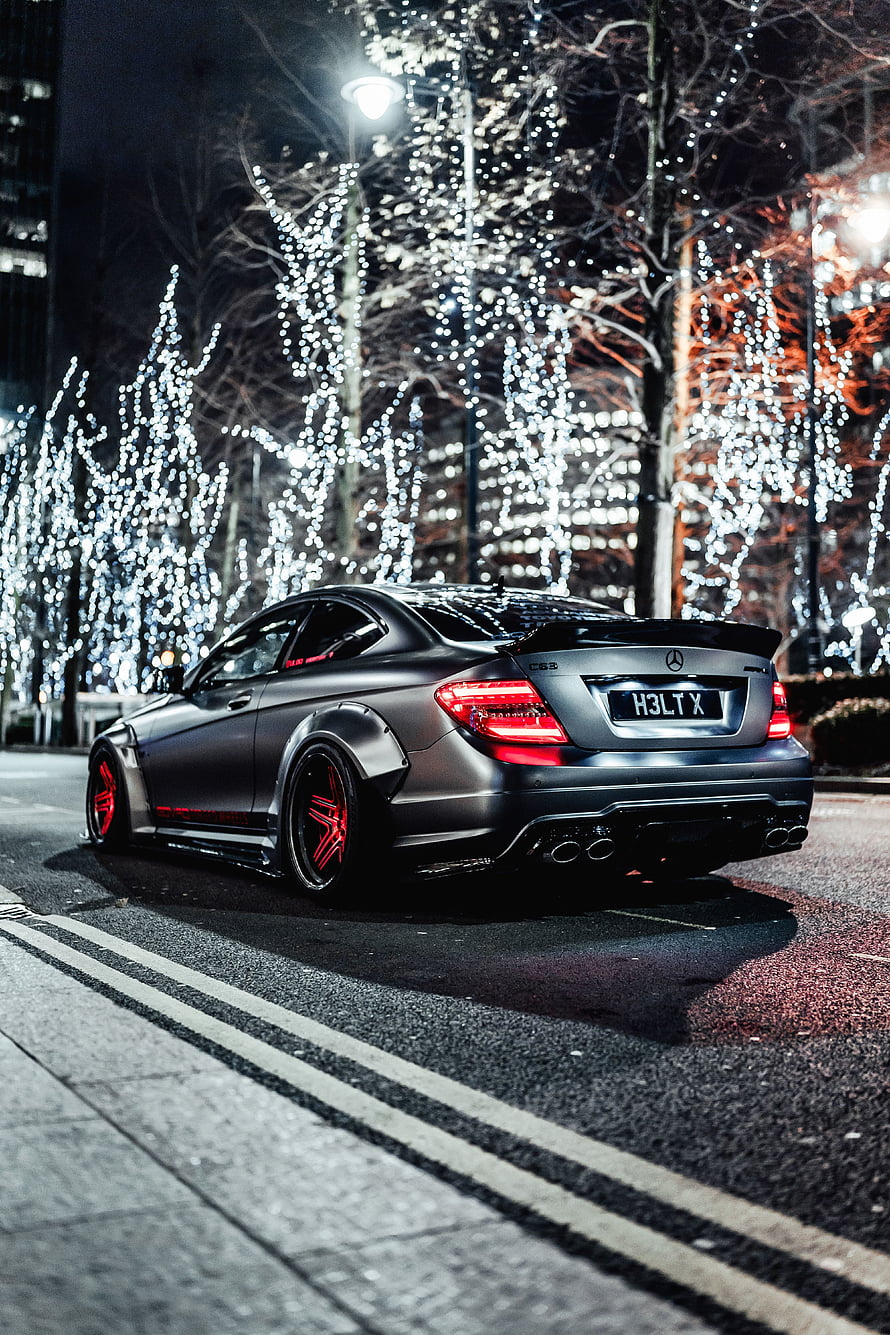Matte Grey Mercedes-Benz C63 AMG Coupe with Red Rims Parked on a City Street at Night HD phone wallpaper