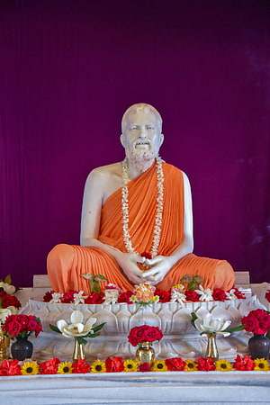 Sri Ramakrishna Statue at Belur Math with Orange Robes and Floral Offerings HD phone wallpaper