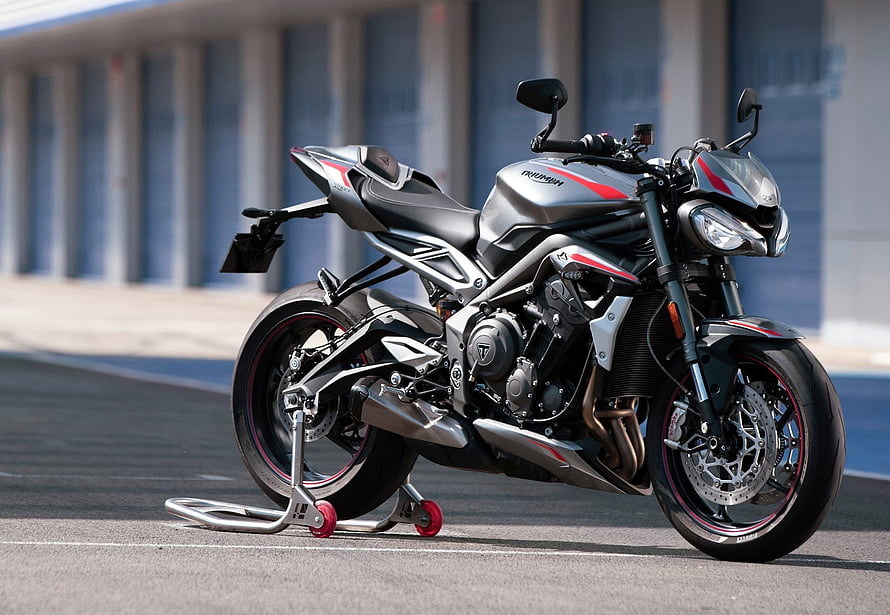 Triumph Street Triple RS sport motorcycle in silver and red parked on a racetrack HD wallpaper