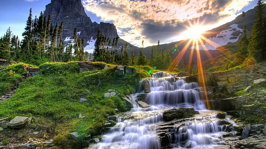 Sunlit Mountain Waterfall Cascading Through Lush Green Valley at Golden Hour HD wallpaper