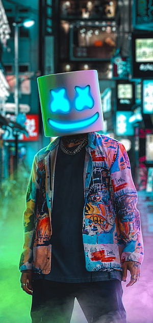 Marshmello in a colorful graffiti jacket standing in a neon-lit urban street at night HD phone wallpaper