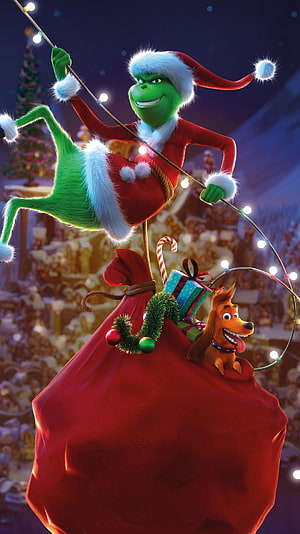 The Grinch and Max in Santa Costume Hanging from Christmas Lights with Gift Sack HD phone wallpaper