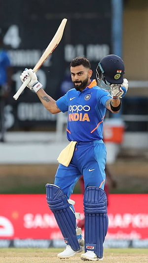 Virat Kohli in India ODI kit raising bat and helmet on the cricket field HD phone wallpaper