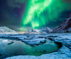 Vibrant Green Aurora Borealis Over Snow-Capped Norwegian Mountains and Frozen Coastline HD wallpaper