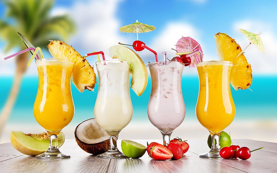 Tropical Fruit Smoothies with Pineapple and Coconut on a Beach Table HD wallpaper