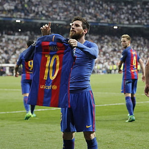 Lionel Messi holding up Barcelona jersey on the pitch during a match celebration HD phone wallpaper