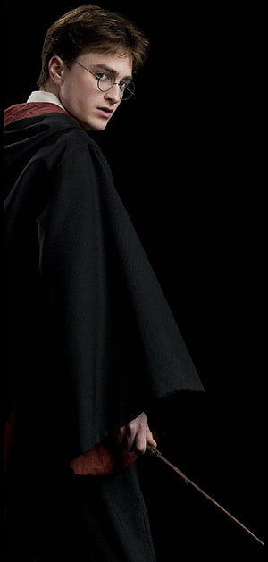 Daniel Radcliffe as Harry Potter in a dark robe holding a wand against a black background HD phone wallpaper