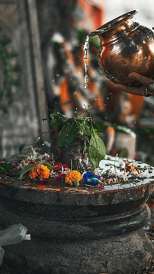 Shiv Pind Ritual: Water Poured from Copper Pot onto Sacred Stone with Marigold Flowers HD phone wallpaper