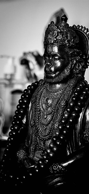 Black and White Hanuman Idol Statue with Ornate Crown and Beaded Garlands HD phone wallpaper