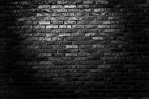 Moody Black Brick Wall Texture with Dramatic Lighting and Deep Shadows HD wallpaper