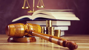 Wooden Gavel and Scales of Justice with Law Books and Coins on a Desk HD wallpaper