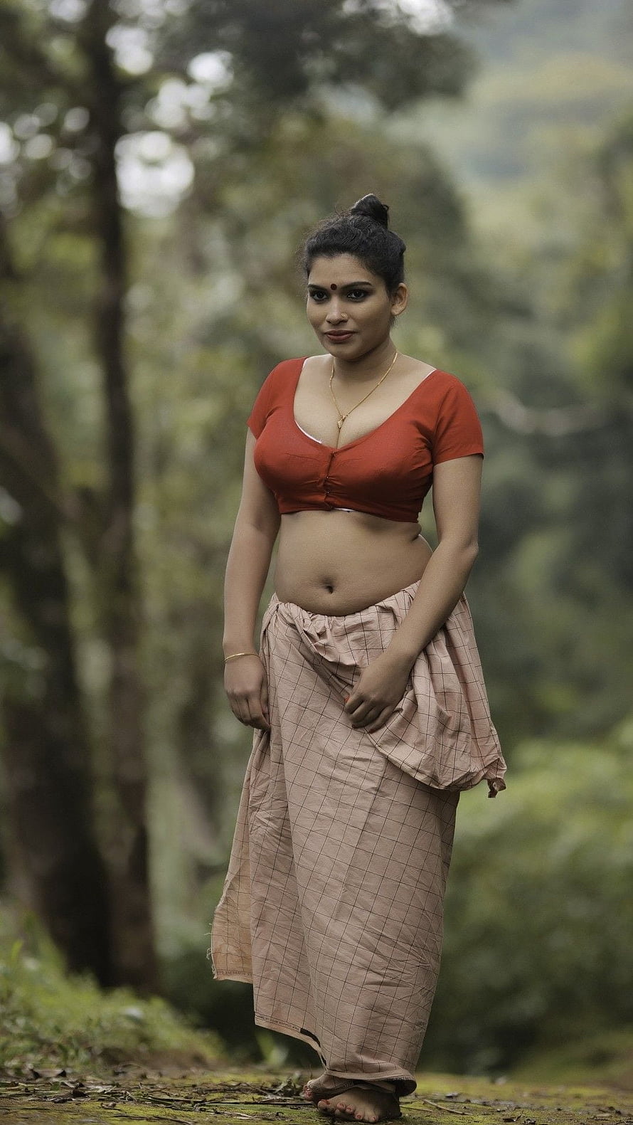 Reshmi Nair in Traditional Attire Standing in a Lush Forest Setting HD phone wallpaper
