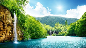 Serene Waterfall Cascading Into Turquoise Lake Surrounded By Lush Green Forest And Mountains HD wallpaper