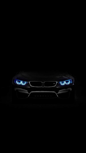 Black BMW M4 Front View with Glowing Blue Angel Eyes Headlights in Darkness HD phone wallpaper