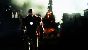 Iron Man Walking Through a War-Torn Battlefield with Explosions and Smoke HD wallpaper