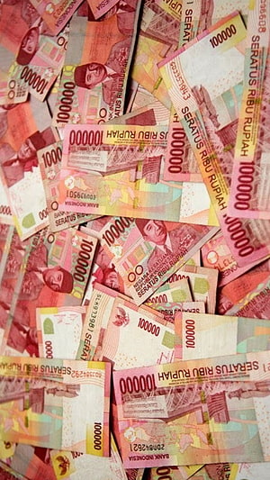 Scattered Indonesian Rupiah Banknotes in Warm Tones HD phone wallpaper