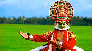Traditional Kathakali Dancer in Vibrant Green Face Paint and Red Attire HD wallpaper
