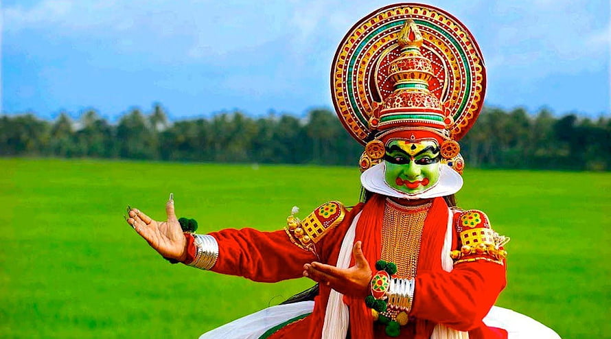 Traditional Kathakali Dancer in Vibrant Green Face Paint and Red Attire HD wallpaper