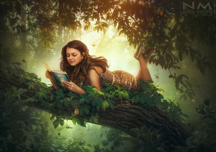 Young Woman Reading a Book on a Mossy Tree Branch in a Sunlit Fantasy Forest HD wallpaper