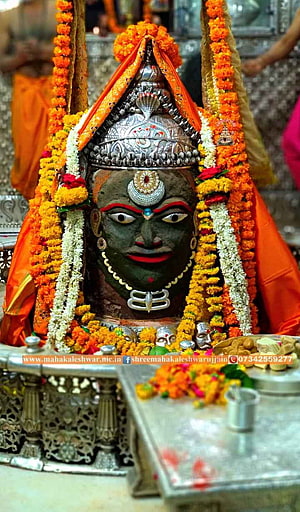 Mahakaleshwar Jyotirlinga deity adorned with marigold garlands and silver crown in Ujjain temple HD phone wallpaper