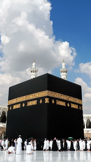 The Kaaba in Mecca with Pilgrims at Masjid Al Haram Under a Blue Sky HD phone wallpaper